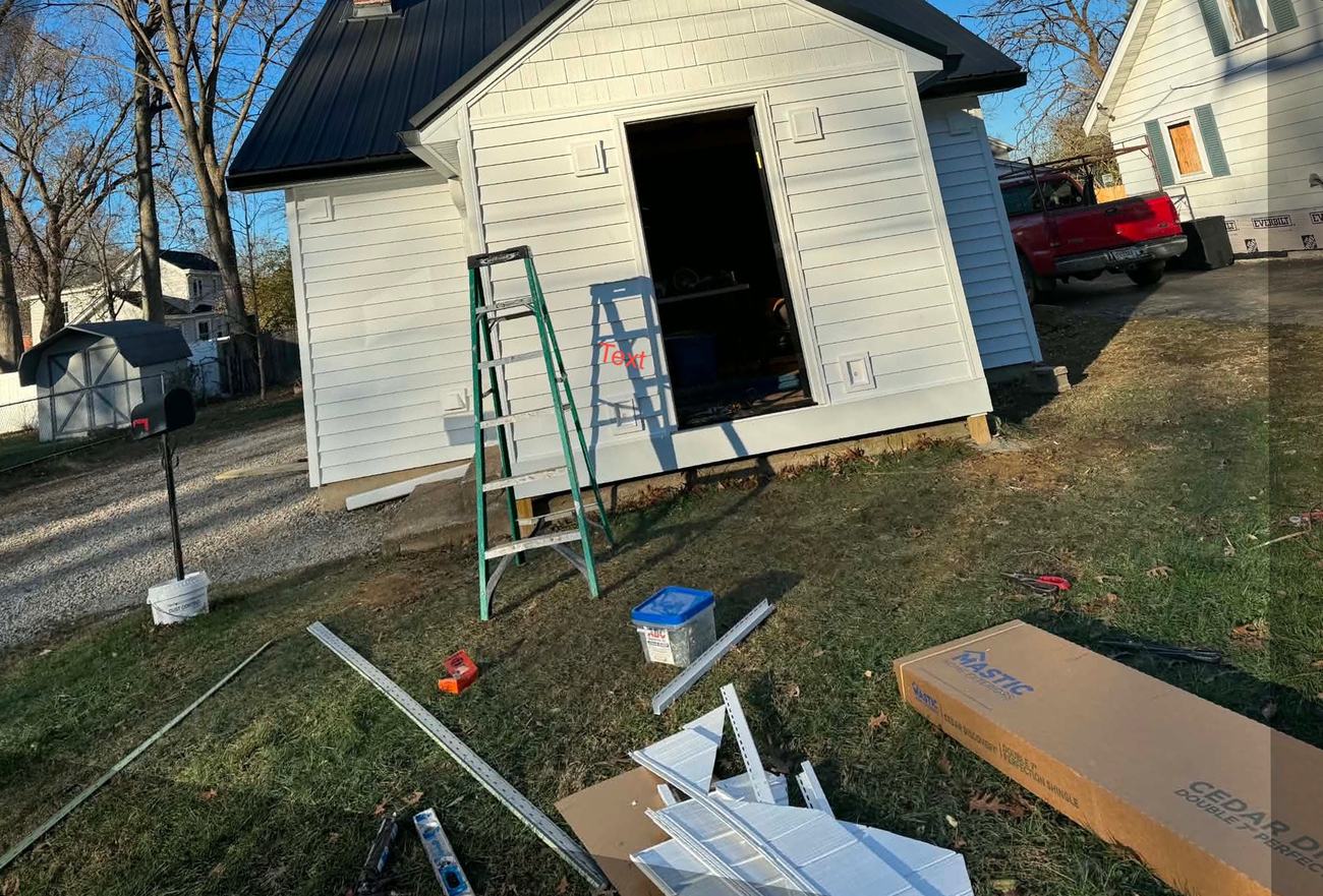 New white lap siding installed on a detached garage